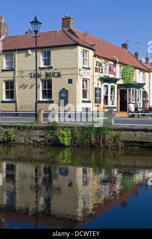 Buck Inn Great Ayton spiegelt sich in den Fluss Leven, schwülen Sommernachmittagen Leute sitzen draußen, North Yorkshire England UK Stockfoto