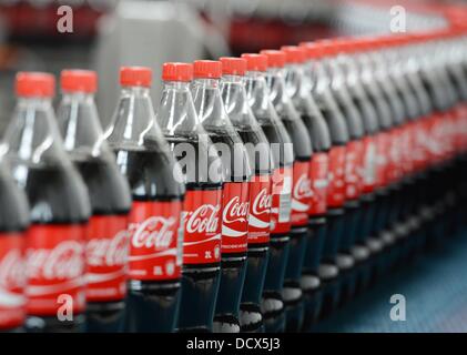 Zwei-Liter-Coca-Cola-Flaschen sind in der Produktion in die Abfüllanlage von Coca-Cola Erfrischungsgetränke AG-Produktionsstätte in Genshagen, Deutschland, 21. August 2013 abgebildet. Hier werden Coca-Cola Produkte in Einwegverpackungen auf 158.000 Quadratmeter gefüllt. 170 Mitarbeiter arbeiten in der Fertigung, das 1998 eröffnet wurde. Die Coca-Cola Erfrischungsgetränke AG ist eines der größten Getränkeunternehmen in Deutschland mit einem Umsatz von 3,7 Milliarden Liter im Jahr 2012. Foto: Jens Kalaene Stockfoto