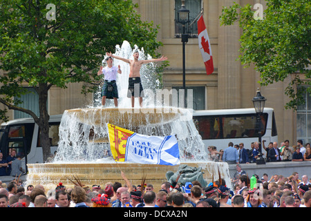 Schottische Fußballfans klettern auf den Trafalgar Square Fountain People um den Trafalgar Square London, um das Spiel zwischen dem englischen schottischen Team Wembley UK zu erleben Stockfoto