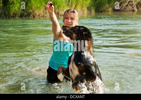 Hund und Mädchen spielen im Wasser Stockfoto