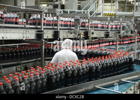 Ein Mitarbeiter ist neben der Produktionslinie in die Abfüllanlage von Coca-Cola Erfrischungsgetränke AG-Produktionsstätte in Genshagen, Deutschland, 21. August 2013 abgebildet. Hier werden Coca-Cola Produkte in Einwegverpackungen auf 158.000 Quadratmeter gefüllt. 170 Mitarbeiter arbeiten in der Fertigung, das 1998 eröffnet wurde. Die Coca-Cola Erfrischungsgetränke AG ist eines der größten Getränkeunternehmen in Deutschland mit einem Umsatz von 3,7 Milliarden Liter im Jahr 2012. Foto: Jens Kalaene Stockfoto