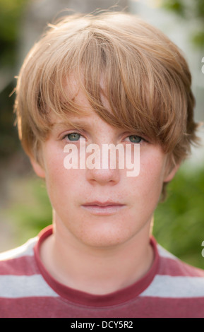 Moderne Portrait of Young Boy mit blauen Augen und Sommersprossen Hintergrundbeleuchtung im Sommer. Stockfoto