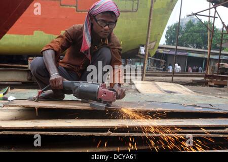 Eine Arbeiterin aus Bangladesch arbeitet auf einer Fähre renoviert auf einer Werft in Keraniganj, in der Nähe von Dhaka, Bangladesch, Mittwoch, August 21, 2013. Arbeiter, die in der Gebäude Fähren, die Schweißen, Schneiden und Malen, verdienen weniger als US $ 4 pro Tag. Stockfoto