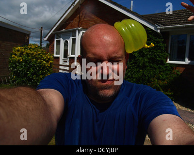 Mann von mit Wasser gefüllten Ballons getroffen Stockfoto