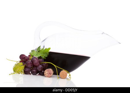 Rotwein in luxuriösen Karaffe mit roten Trauben, Weinlaub und Weinkorken isoliert auf weißem Hintergrund mit Reflexion. Stockfoto