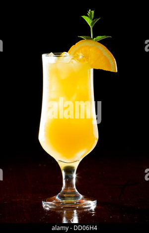 Schraubendreher, frischen Orangensaft mit Wodka serviert in einem Stamm Glas auf einem dunklen Balken Stockfoto