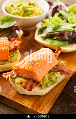 Gegrillter Lachs Sandwich mit Speck und Guacamole auf Brot Stockfoto