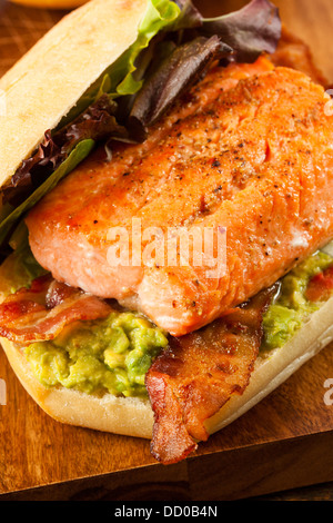 Gegrillter Lachs Sandwich mit Speck und Guacamole auf Brot Stockfoto