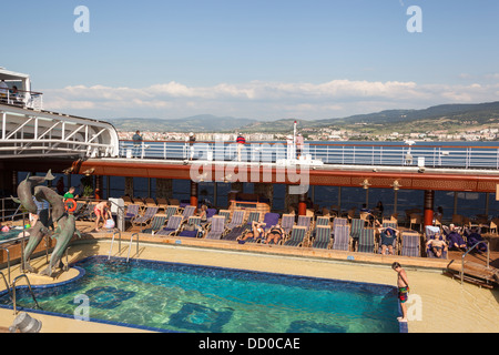 Passagiere, die von einem Pool, der Noordam entspannende Kreuzfahrtschiff, eines der Holland America Line Flotte in den Dardanellen Stockfoto