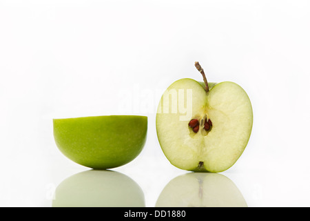 Studio Aufnahme von grünem Apfel halbieren zeigt Samen Stockfoto