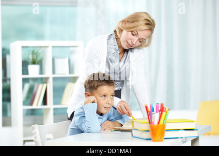 Porträt von müde Jungen und seinem Lehrer erklären, etwas in der Nähe von Stockfoto