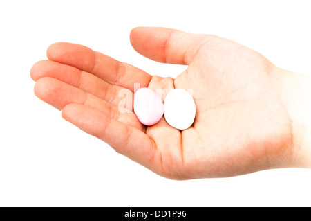 Hand mit Süßigkeiten auf weißem Hintergrund Stockfoto