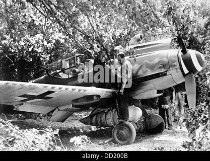 Mitglieder von der Maschine pflegen eine Messerschmitt Me 109 der deutschen Wehrmacht für die nächsten Kampfeinsatz im September 1944 auf getarnte Territorium. Der NS-Propaganda! auf der Rückseite, wenn Bild 1. September 1944 datiert ist: "die Me 109 ist bereit für den Abflug durch die Maschine am Rande des Flugplatzes erweiterte. Enge Begleitung Flugzeuge und Kämpfer Flugzeuge fliegen gemeinsam in das Kampfgebiet. Die Me 109 fungiert als Jagdschutz. Mit einem zusätzlichen Tank, die bereits in die gut getarnten Maschine aufgehängt ist, auch die Kämpfer Flugzeuge können lange Strecken fliegen. " Foto: Berliner Verlag / A Stockfoto