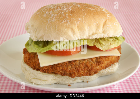 Hähnchenfilet Burger in Semmelbrösel mit Käse, Salat und Tomate auf ein frisches Brot Brötchen Stockfoto