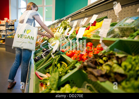 Eine Frau schaut Gemüse im veganen Supermarkt "Veganz" in Berlin, Deutschland, 22. August 2013. Foto: Ole Spata Stockfoto