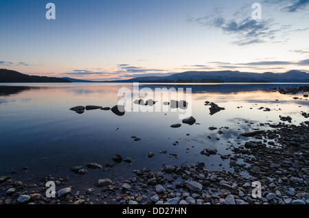 Ruhigen Abend Landschaft mit Steinen an den Ufern des Loch Lomond, Schottland, mit dem Sonnenuntergang widerspiegelt in dem Loch Stockfoto