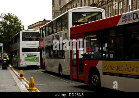 Drei National Express-Busse parken entlang Commercial Street, Passagiere an der Bushaltestelle in Dundee, Großbritannien zu sammeln Stockfoto