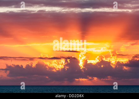Dramatische Schuss der Lichtstrahlen bei Sonnenuntergang über dem Ozean Stockfoto