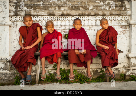 Junge Mönche sitzen auf Bank in Burma Myanmar Stockfoto