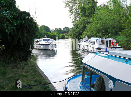 Boote auf dem Fluss Bure auf den Norfolk Broads in Belaugh, in der Nähe Wroxham, Norfolk, England, Vereinigtes Königreich. Stockfoto