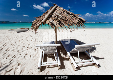 Sonnenschirm mit Stuhl Longues am tropischen Strand Boracay Stockfoto
