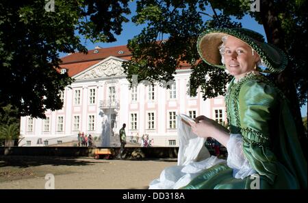 Berlin, Deutschland. 24. August 2013. Eine Schauspielerin stickt in ein historisches Kostüm während des Rokoko-Festival im Schloss Friedrichsfelde in Berlin, Deutschland, 24. August 2013. Das Festival präsentiert historische Tänze, einer Burg-Messe und Konzerte am Wochenende. Foto: Jörg CARSTENSEN/Dpa/Alamy Live News Stockfoto