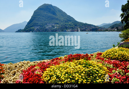 Schweiz - Lago di Lugano - Lugano Stadt - bunte Gärten am See - Blick über den See nach Monte Bre - Sonnenlicht Stockfoto