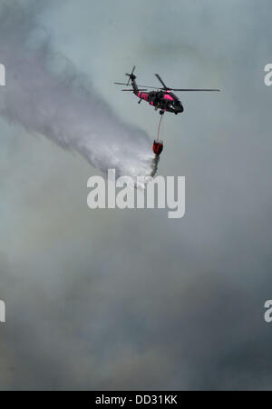 23. August 2013 - Buck Meadows, Kalifornien, Tropfen US - A National Guard Helikopter Wasser auf dem Rim Feuer. Rim Fire in der Stanislaus National Forest entlang Highway 120 wächst weiter. Laut dem US Forest Service ab Freitag Aug. 23. 2013 am Nachmittag das Feuer auf 125.620 Hektar mit nur 2 % Containment mit mehr Evakuierungen in Tuolumne Stadt und Umgebung entlang der Autobahn 108 angewachsen ist. In mehrere Richtungen einschließlich Richtung Yosemite National Park breitet sich das Feuer weiter. (Kredit-Bild: © Marty Bicek/ZUMAPRESS.com) Stockfoto