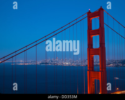 Einen spektakulären Blick auf die Golden Gate Bridge zur blauen Stunde mit die beleuchtete Skyline von San Francisco im Hintergrund. Stockfoto