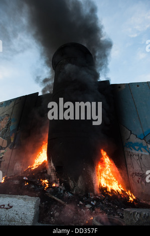 Ein Feuer brennt in einem Turm in der israelischen Trennmauer im Zuge der Auseinandersetzungen im Flüchtlingslager Aida in der West Bank von Bethlehem Stockfoto