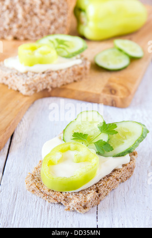 Vegetarisches Sandwich (Imbiss) mit Vollkornbrot, Käse und Gemüse (Paprika, Gurke, Petersilie) Großaufnahme vertikal Stockfoto