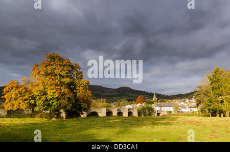 Herbstliche Bäume um eine ländliche Gemeinde mit einem stürmischen grauen Himmel Stockfoto