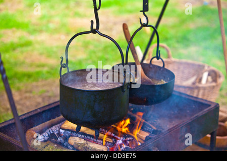 Mahlzeit im Freien mit Töpfen auf offenem Feuer kochen. Stockfoto