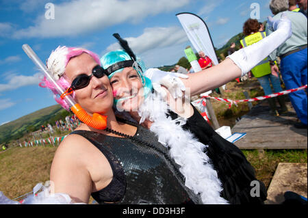 Llanwrtyd Wells, UK. 25. August 2013. Hannah Fraser (R) und Gemma Fry (L) – The Happy Flapper – beide lokale Damen Freizeit dress up für das Moor.  Der jährlichen Weltmeisterschaft Bogsnorkelling findet jeden August Bank Holiday im berühmten Wän Rhydd Bog.in die Waliser der Cambrian Mountains in der Nähe von der kleinsten Stadt in Großbritannien bekannt für seine skurrilen Sport. Die Idee entstand im Jahr 1985 durch Vermieter Gordon Green The Neuadd Arms Pub Llanwrtyd Wells auf die Karte setzen. Weltmeister ist Andrew Holmes mit einer Zeit von 84secs im Jahr 2011. Foto: Graham M. Lawrence/Alamy Live-Nachrichten. Stockfoto