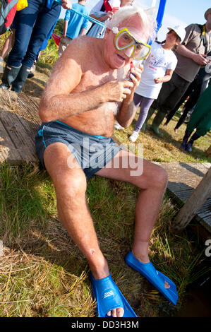 Llanwrtyd Wells, UK. 25. August 2013. Bogsnokelling Gründer Gordon Green 79, braucht, um das Moor. Der jährlichen Weltmeisterschaft Bogsnorkelling findet jeden August Bank Holiday im berühmten Wän Rhydd Bog.in die Waliser der Cambrian Mountains in der Nähe von der kleinsten Stadt in Großbritannien bekannt für seine skurrilen Sport. Die Idee entstand im Jahr 1985 durch Vermieter Gordon Green The Neuadd Arms Pub Llanwrtyd Wells auf die Karte setzen. Weltmeister ist Andrew Holmes mit einer Zeit von 84secs im Jahr 2011. Foto: Graham M. Lawrence/Alamy Live-Nachrichten. Stockfoto