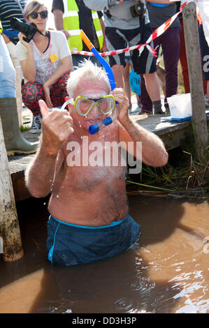 Llanwrtyd Wells, UK. 25. August 2013. Bogsnokelling Gründer Gordon Green 79, braucht, um das Moor. Der jährlichen Weltmeisterschaft Bogsnorkelling findet jeden August Bank Holiday im berühmten Wän Rhydd Bog.in die Waliser der Cambrian Mountains in der Nähe von der kleinsten Stadt in Großbritannien bekannt für seine skurrilen Sport. Die Idee entstand im Jahr 1985 durch Vermieter Gordon Green The Neuadd Arms Pub Llanwrtyd Wells auf die Karte setzen. Weltmeister ist Andrew Holmes mit einer Zeit von 84secs im Jahr 2011. Foto: Graham M. Lawrence/Alamy Live-Nachrichten. Stockfoto