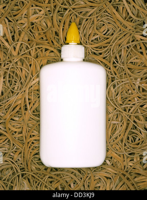 Eine Flasche von Weißleim auf einem Hintergrund von Gummibändern. Stockfoto