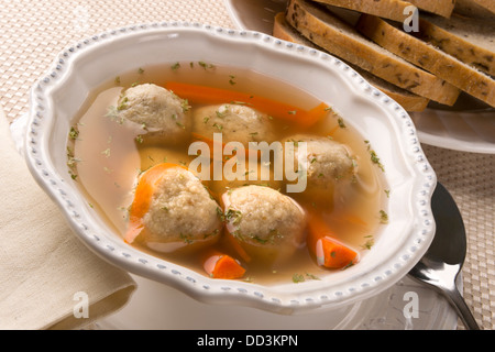 Traditionelle jüdische Passahfest dish Matza Ball Suppe serviert mit Roggenbrot Stockfoto