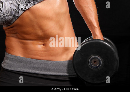 Attraktive junge Frau, die mit Gewichten trainieren Stockfoto