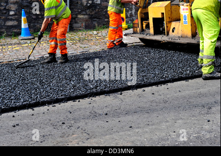 Arbeiter, die Verbreitung von Asphalt während Straße Oberflächenersatz Stockfoto