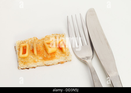 Diät-Konzept, kleines Stück Toast mit Diät geschrieben, mit Alphabet Spaghetti mit Messer und Gabel auf einem Teller Stockfoto