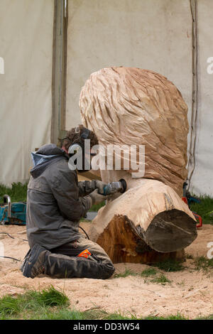 Tabley, Cheshire, UK 25 August, 2013. Simon O'Rourke auf der 9. englischen Öffnen Chainsaw Carving Wettbewerb, Cheshire County Showground, Spiel und County Fair, Tabley, Nr Knutsford, Großbritannien. Die Kettensäge Carver Holz (manchmal riesige Bits) schönen Schnitzereien von bis zu 20 Meter hoch zu produzieren. Wenn jeder wird gesucht nach Kunstwerk holz skulptur, Sägemehl, Bildhauer, Holz, Späne, Log, professionell, arbeiten, Kunst, Künstler, Ausschneiden, Kettensäge, Kunstwerke aus grobem Holz Log gemacht. Stockfoto