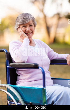 fröhliche senior Frau sitzt auf einem Rollstuhl im freien Stockfoto