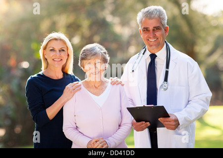 Doktor der Medizin mit älteren Patienten und ihre Tochter im Freien stehen Stockfoto
