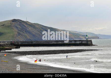 Aberystwyth, Wales, UK. 25. August 2013. RNLI Rettungsschwimmer schützen Schwimmer am Südstrand, Aberystwyth, mit der zerklüfteten Küste der Ceredigion darüber hinaus. Die roten-gelben Flaggen markieren den sicheren Badebereich - 25. August 2013. Bildnachweis: John Gilbey/Alamy Live News. Stockfoto