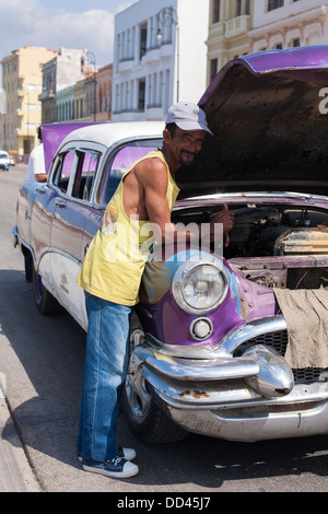 Ein Mann arbeitet auf dem Motor des amerikanischen Oldtimer auf der Straße mit der Haube und aufgewachsen in Havanna Kuba Stockfoto