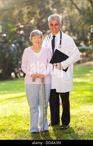 lächelnde senior Frau stehend mit mittleren Alter Arzt in Seniorenwohnanlage Stockfoto
