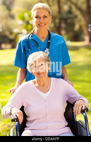 lächelnde Krankenschwester mit behinderten Patienten im freien Stockfoto