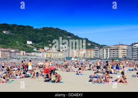 Große Schar von Menschen Baden während einer heißen Mitte Sommertag am Strand Gros in San Sebastian, Nordspanien Stockfoto