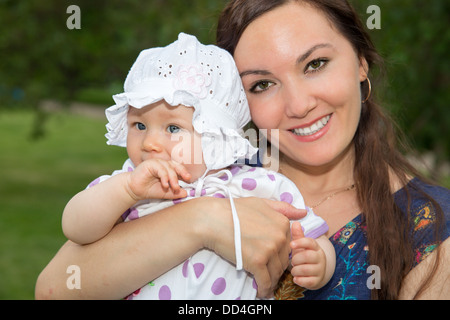 Glückliche Mama und Kind Mädchen umarmt. Das Konzept von Kindheit und Familie. Schöne Mutter und ihr Baby im freien Stockfoto